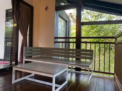 a bench sitting on a porch with a window at Cahaya Villa in Tanah Rata