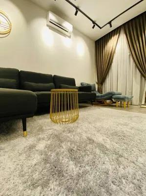 a living room with a black couch and a table at SIX Boutique Residence @ Ipoh Garden Landed House 8pax in Ipoh