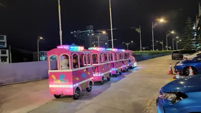 a row of pink train cars parked in a parking lot at The Gladiator Homstay in Brinchang