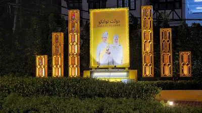 a billboard with a picture of a man and a woman on it at The Gladiator Homstay in Brinchang