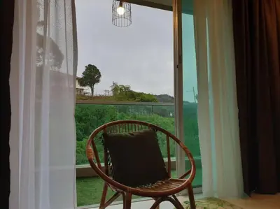 a chair sitting in front of a window at ForestNest Cameron Town Spacious 3R3B (1300 sqft) in Tanah Rata