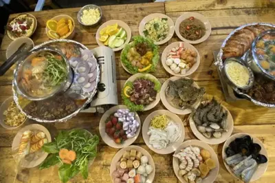 a wooden table topped with lots of plates of food at ForestNest Cameron Town Spacious 3R3B (1300 sqft) in Tanah Rata
