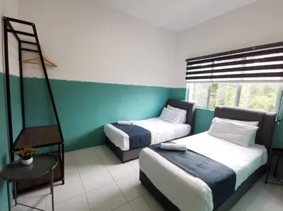 a bedroom with two beds and a blue and white wall at ForestNest Cameron Town Spacious 3R3B (1300 sqft) in Tanah Rata