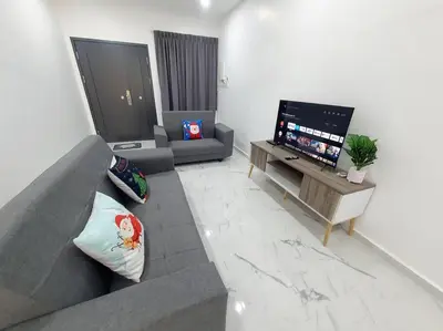 a living room with a gray couch and a flat screen tv at (New)Jovial Cozy&Stylish House 4Room@BM Sri Rambai in Bukit Mertajam