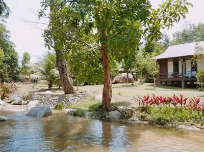 a house with trees and a river in front of it at D'Impiana Riverview Chalet # Lenggong in Kampong Ulu Jepai