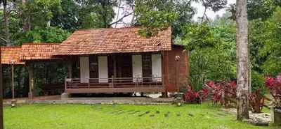 a small house with a porch in a garden at D'Impiana Riverview Chalet # Lenggong in Kampong Ulu Jepai