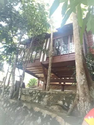 a wooden house with trees in front of it at D'Impiana Riverview Chalet # Lenggong in Kampong Ulu Jepai
