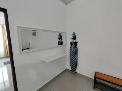 a white wall with a mirror and a tie on it at Homestay Studio Apartment Bentara Suite, Kompleks Mutiara Gua Musang in Gua Musang