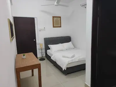 a small bedroom with a bed and a table at Homestay Studio Apartment Bentara Suite, Kompleks Mutiara Gua Musang in Gua Musang