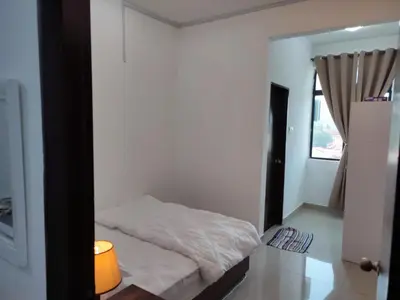 a bedroom with a white bed and a window at Homestay Studio Apartment Bentara Suite, Kompleks Mutiara Gua Musang in Gua Musang
