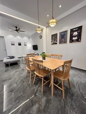 a dining room with a wooden table and chairs at Inn Homestay 2nd Floor Jasmine and Lavender unit in Teluk Intan