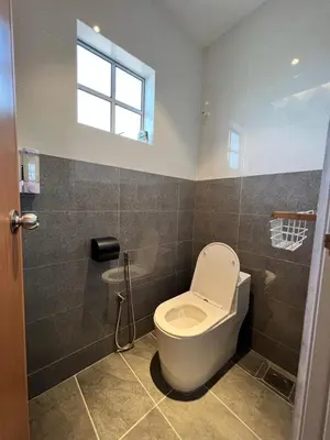 a bathroom with a white toilet and a window at Inn Homestay 2nd Floor Jasmine and Lavender unit in Teluk Intan