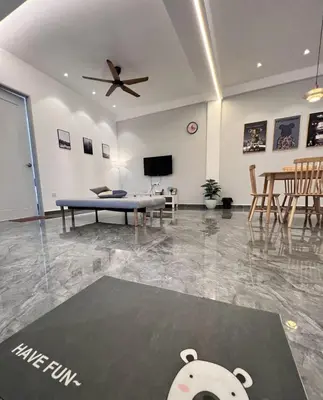a living room with a table and a ceiling fan at Inn Homestay 2nd Floor Jasmine and Lavender unit in Teluk Intan