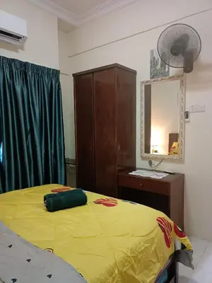 a bedroom with a yellow bed and a mirror at Sofea Inn Bukit Merah - Laketown A6153 in Kampong Selemat