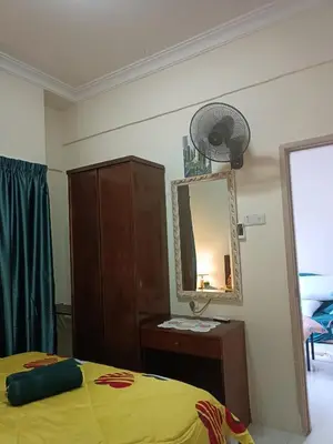 a bedroom with a bed and a mirror and a fan at Sofea Inn Bukit Merah - Laketown A6153 in Kampong Selemat