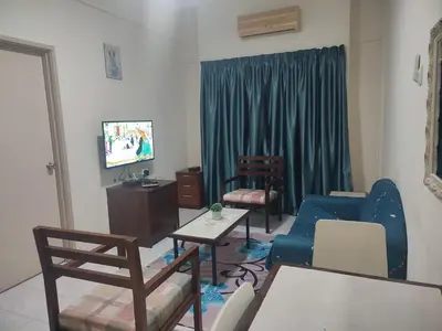 a living room with a blue couch and a tv at Sofea Inn Bukit Merah - Laketown A6153 in Kampong Selemat