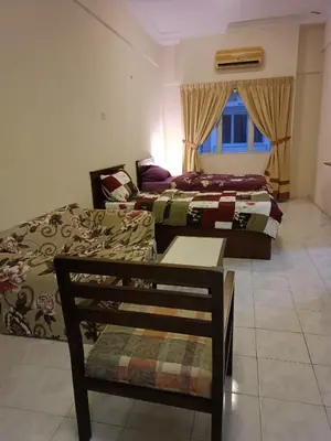 a bedroom with two beds and a chair and a window at Sofea Inn Bukit Merah - Laketown A6172 in Kampong Selemat