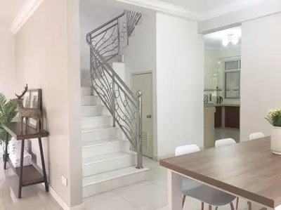 a dining room and kitchen with a staircase in a house at Family 4BR Landed House @ SPICE ARENA in Bayan Lepas