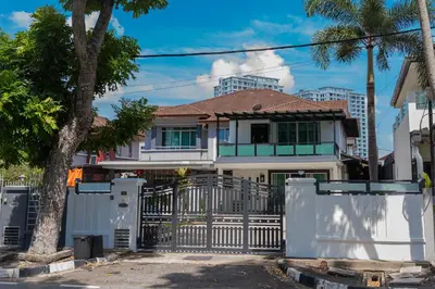 a white house with a gate and palm trees at GARDEN COZY2STOREY HOME 4ROOM 10PAX@NEAR ALMAJUSCO in Bukit Mertajam