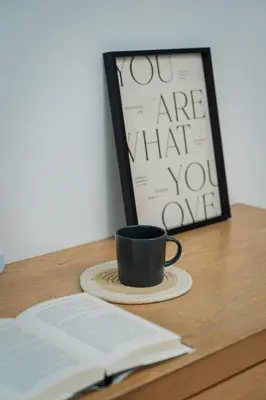 a cup of coffee and an open book on a desk at GARDEN COZY2STOREY HOME 4ROOM 10PAX@NEAR ALMAJUSCO in Bukit Mertajam