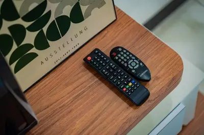 two remote controls sitting on a table next to a box at GARDEN COZY2STOREY HOME 4ROOM 10PAX@NEAR ALMAJUSCO in Bukit Mertajam