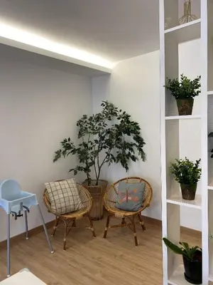 two chairs and a chair in a room with plants at Emerald Avenue Cozy 3R3B Apartment 830 in Brinchang