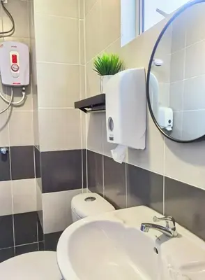 a bathroom with a sink and a mirror and a toilet at Emerald Avenue Cozy 3R3B Apartment 830 in Brinchang