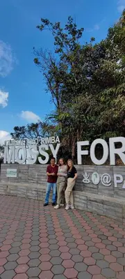 a group of three people standing in front of a sign at Tekoma Hotel & Hostel Cameron Highlands - FREE SHUTTLE SERVICE in Tanah Rata