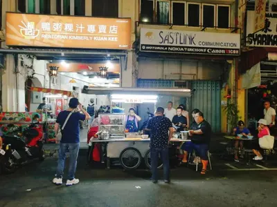 a group of people standing in front of a food truck at sungai ujong home stay in George Town