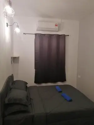 a bed in a room with a black curtain and a window at sungai ujong home stay in George Town