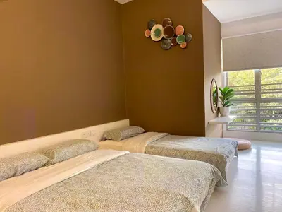 a room with three beds and a clock on the wall at Emerald Avenue Cozy 3R3B Apartment 822 in Brinchang