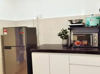 a kitchen with a refrigerator and a microwave at Emerald Avenue Cozy 3R3B Apartment 822 in Brinchang