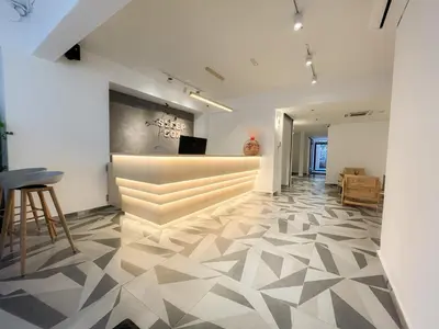 a lobby with a reception area with a geometric tile floor at Sleep Box Penang in George Town