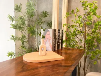 a table with a vase on top of a table with books at Sleep Box Penang in George Town