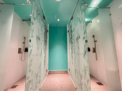 a bathroom with blue walls and a walk in shower at Sleep Box Penang in George Town