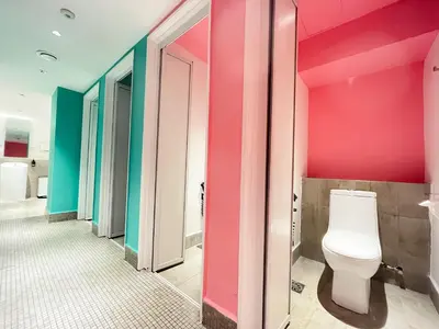 a bathroom with a toilet and colorful walls at Sleep Box Penang in George Town