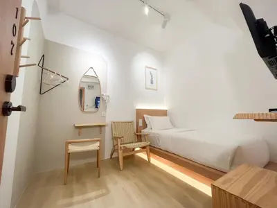 a bedroom with a bed and a table and a chair at Sleep Box Penang in George Town