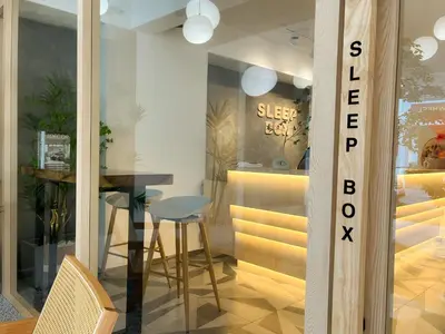 a dining room with a table and a glass window at Sleep Box Penang in George Town