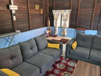 a living room with a couch and a table at Teratak Desa Umaira in Tanjung Karang