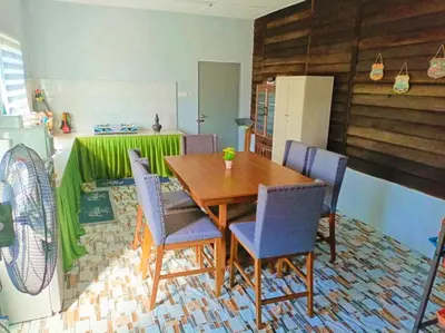 a dining room with a table and blue chairs at Teratak Desa Umaira in Tanjung Karang