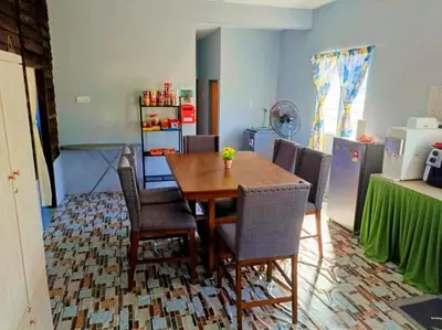 a dining room with a wooden table and chairs at Teratak Desa Umaira in Tanjung Karang