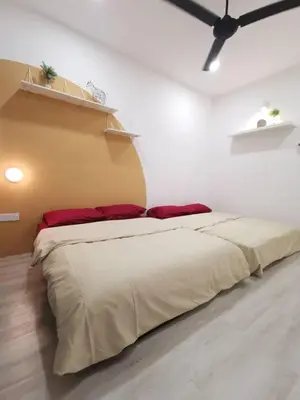 a bedroom with a large bed in a white room at Wellson Home Ipoh 6 (15px+)\u6e29\u99a8\u8212\u9002\u5976\u6cb9\u98ce\u6c11\u5bbf15\u4eba in Ipoh
