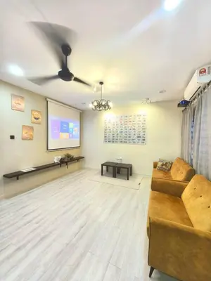 a living room with a couch and a projection screen at Wellson Home Ipoh 6 (15px+)\u6e29\u99a8\u8212\u9002\u5976\u6cb9\u98ce\u6c11\u5bbf15\u4eba in Ipoh