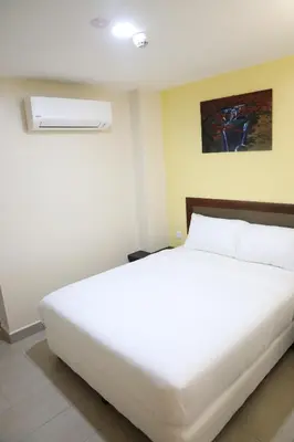 a large white bed in a room with at Capital O 90897 Island City Hotel in George Town