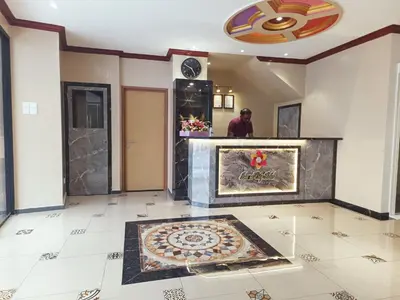 a man standing in a room with a tile floor at Capital O 90897 Island City Hotel in George Town