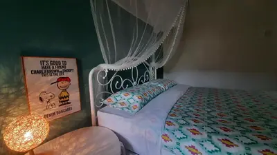 a bedroom with a bed with a canopy and a sign at G Residence - Cosy 4R3B Semi-D in Brinchang Town in Brinchang