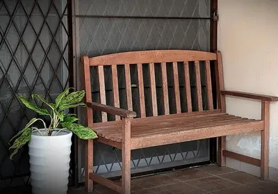 a wooden bench sitting next to a potted plant at G Residence - Cosy 4R3B Semi-D in Brinchang Town in Brinchang