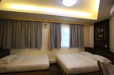 a bedroom with two beds and a window at Shamrock Guest House in Ipoh