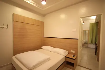 a small bedroom with a bed and a mirror at Shamrock Guest House in Ipoh