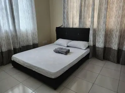 a bed with a black headboard and two pillows on it at Gated Family House- next to MRSM in Kampong Kawak